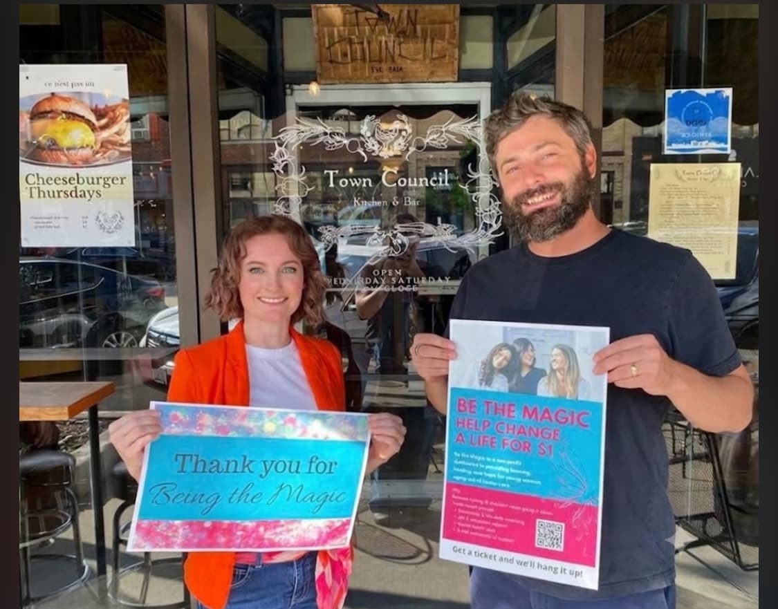 Local business owners holding Be the Magic fundraising signs